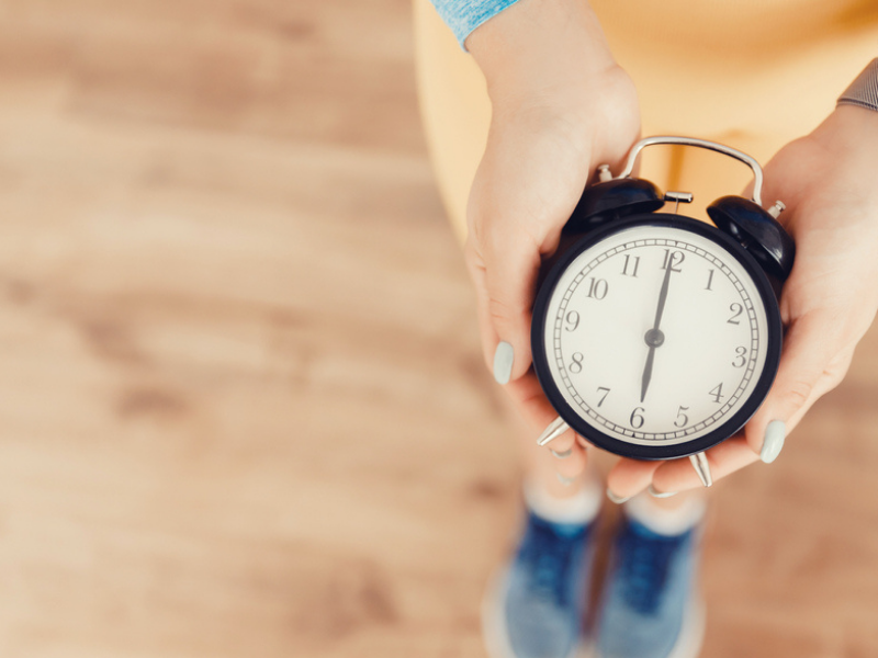 Image of a woman holding a clock