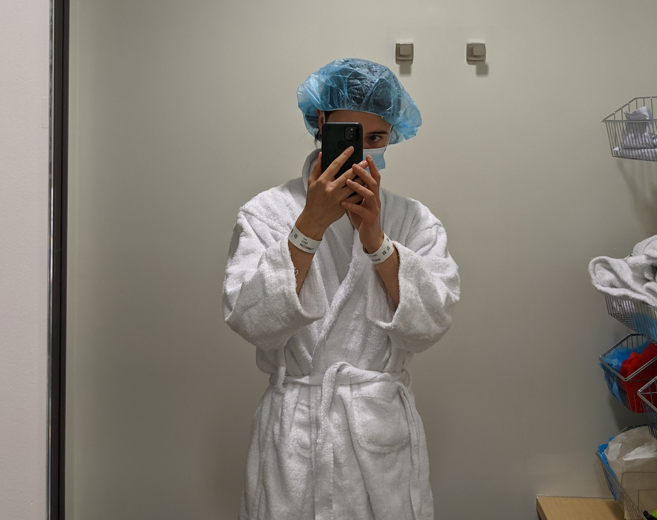 Image of a man wearing hospital robe and cap