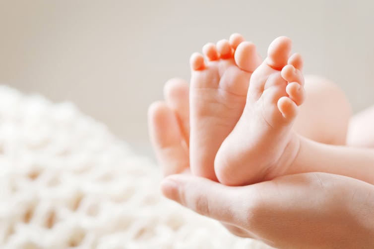 Baby feet held in woman's hands