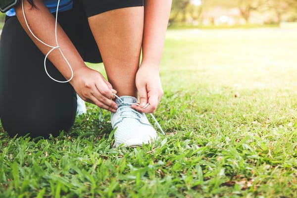 Image of a woman tying her shoes